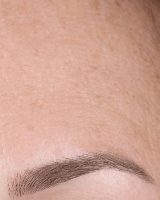 Before-and-after close-up comparison of eyebrow grooming, showing a lighter, less defined eyebrow on the left and a fuller, darker defined eyebrow on the right.