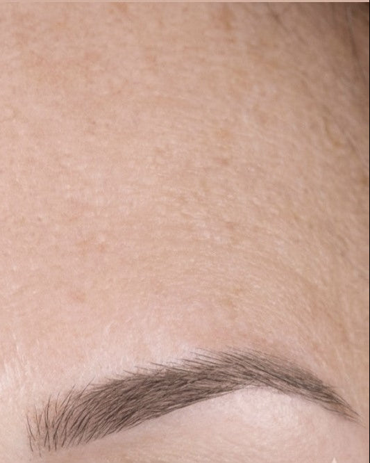 A side-by-side close-up comparison of eyebrows and surrounding skin, showing a before-and-after style view of brow grooming or cosmetic application.